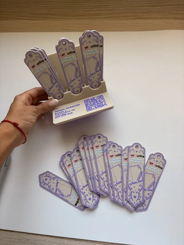 El expositor en la mano, con los marcapáginas delante