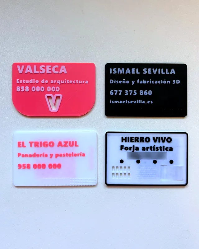 Cuatro tarjetas de visita impresas en 3D, cada una con su diseño y sus colores
