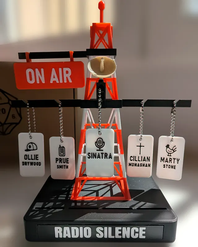 Torre de radio roja y blanca con un cartel ON AIR, una antena parabólica y cinco chapas colgadas de cadenas